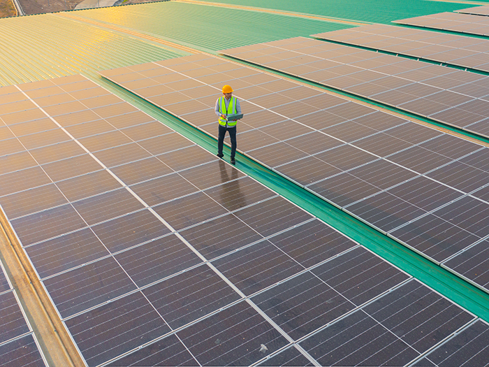 solar technician on roof full of solar panels