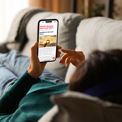 woman laying on couch reading phone