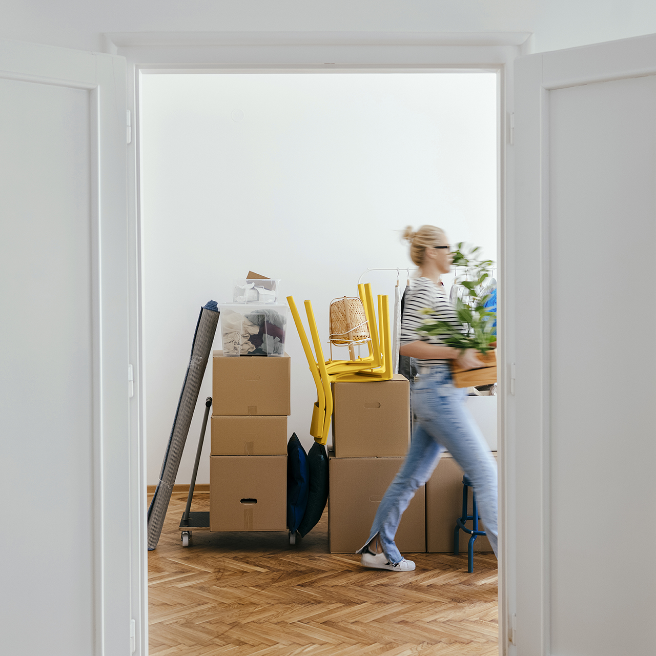 woman walking past doorway with boxes