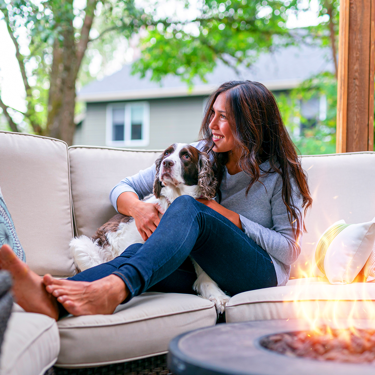 woman hugging dog sitting in front of fire pit