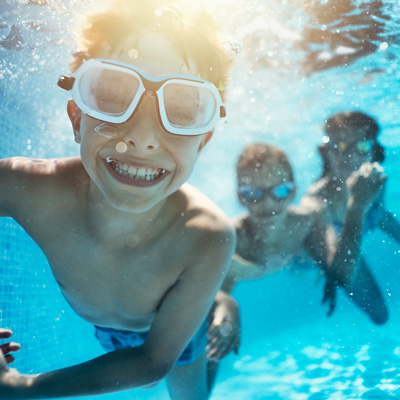 children swimming underwater in pool