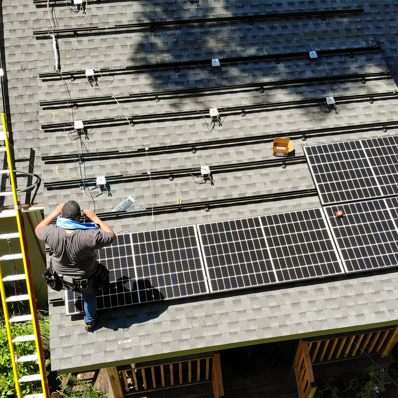solar tech on home's roof installing solar panels
