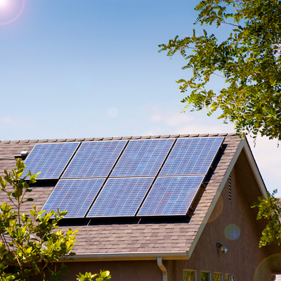 residential house with solar on roof and shining sun blue sky